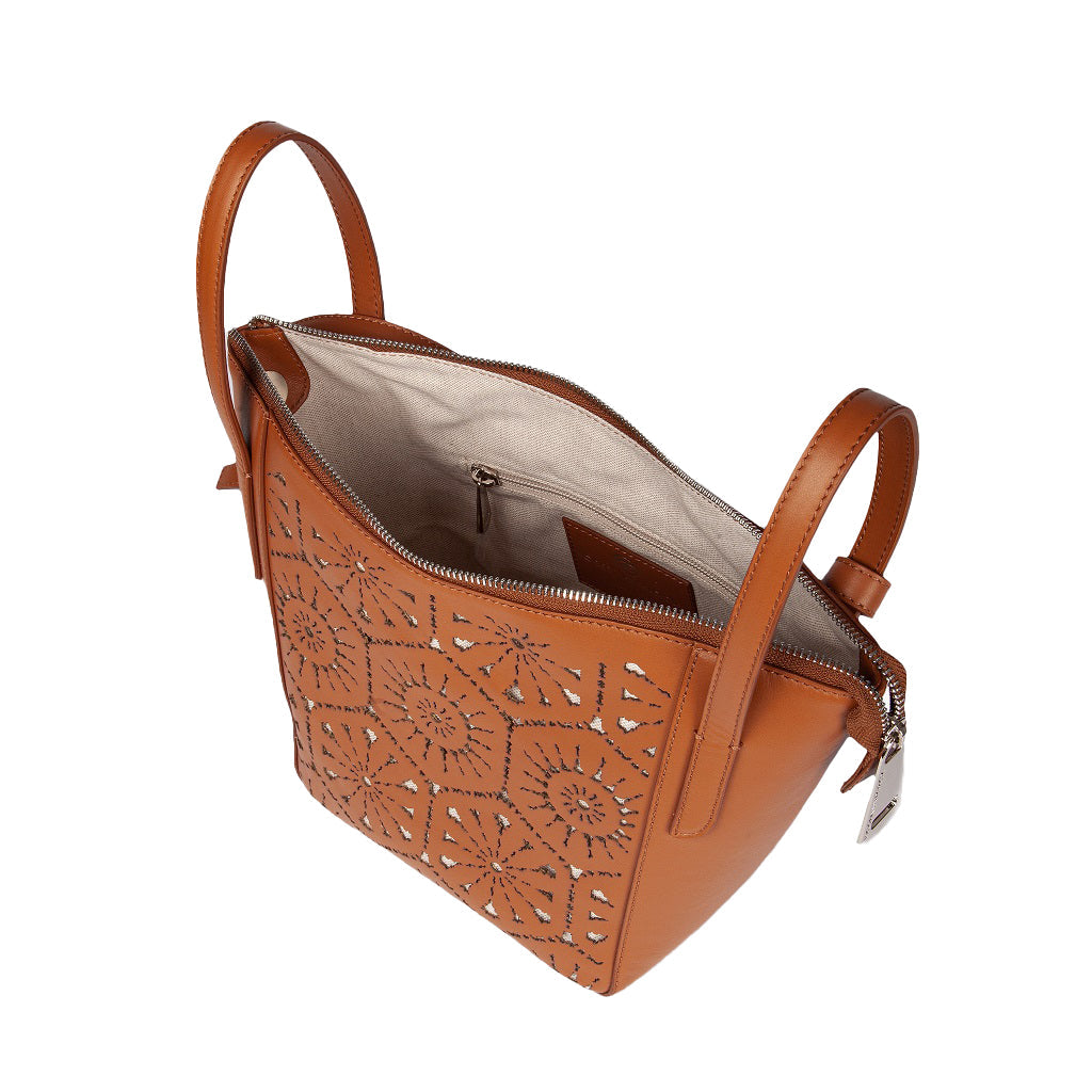 Brown leather handbag with decorative cut-out pattern and open top zipper