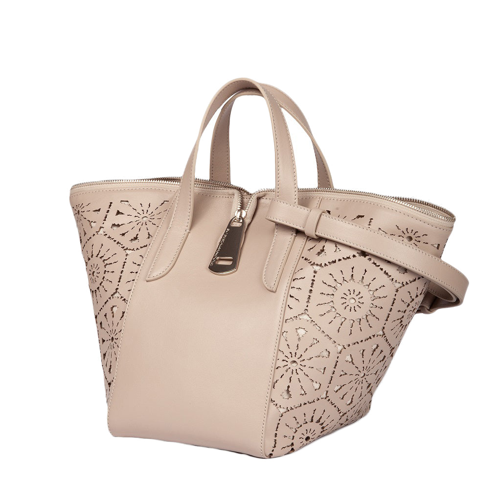 Beige leather handbag with intricate cut-out floral design and shoulder strap