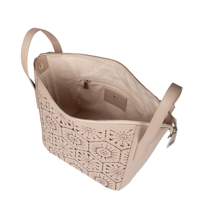 Beige leather handbag with cutout geometric pattern and beige fabric interior