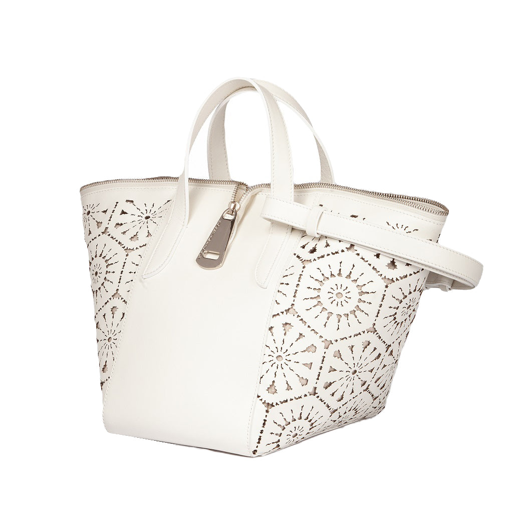 White laser-cut leather handbag with intricate floral patterns and silver hardware