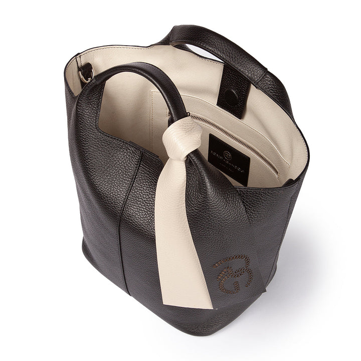 Black leather handbag with beige interior and decorative knot, featuring a logo on the front