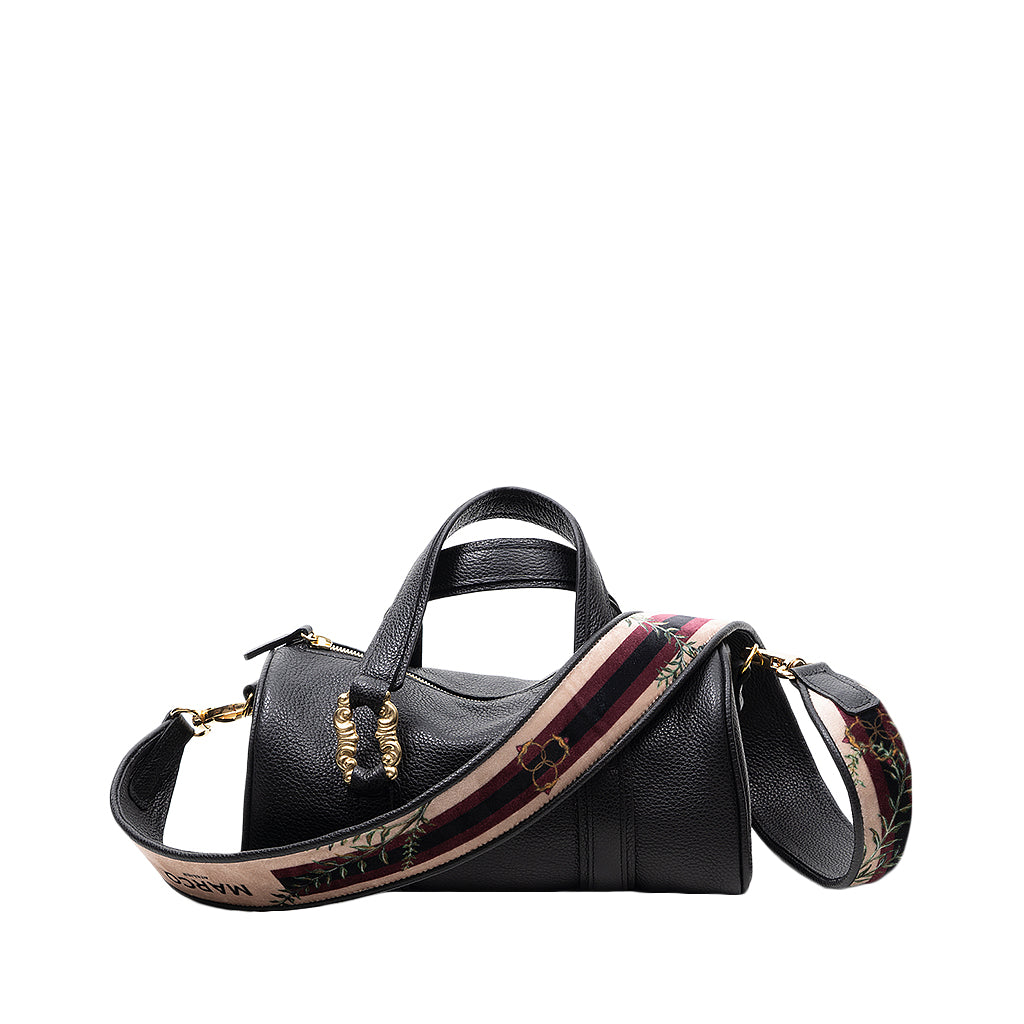 Black leather handbag with a colorful patterned shoulder strap and gold accents