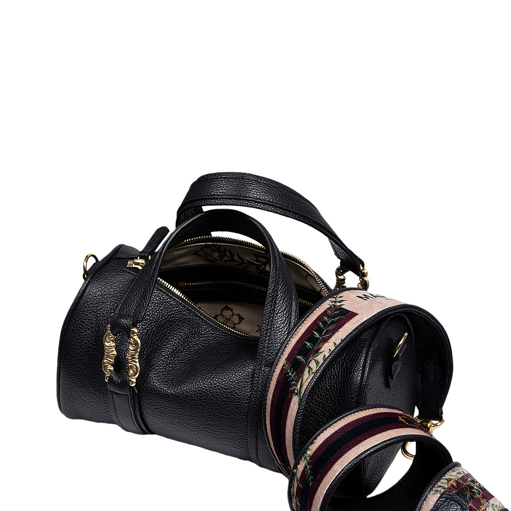 Black leather handbag with decorative gold hardware and embroidered strap, showing interior lining