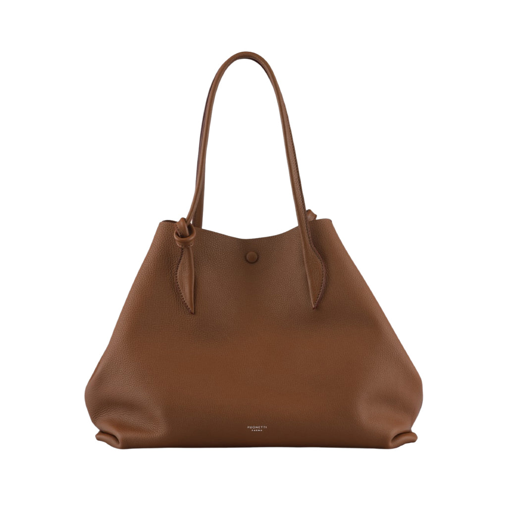 Brown leather tote bag with long handles and a button closure against a white background