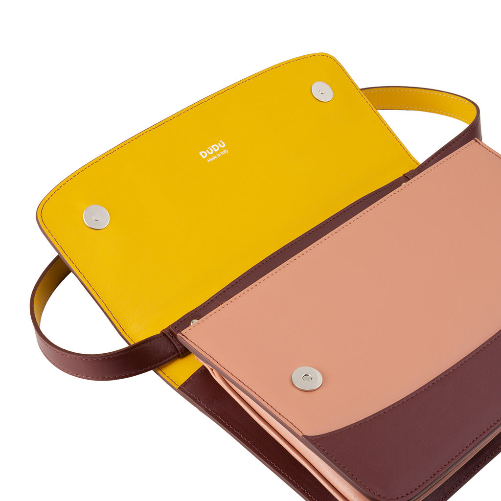 Two-tone leather handbag with open yellow interior and magnetic clasps