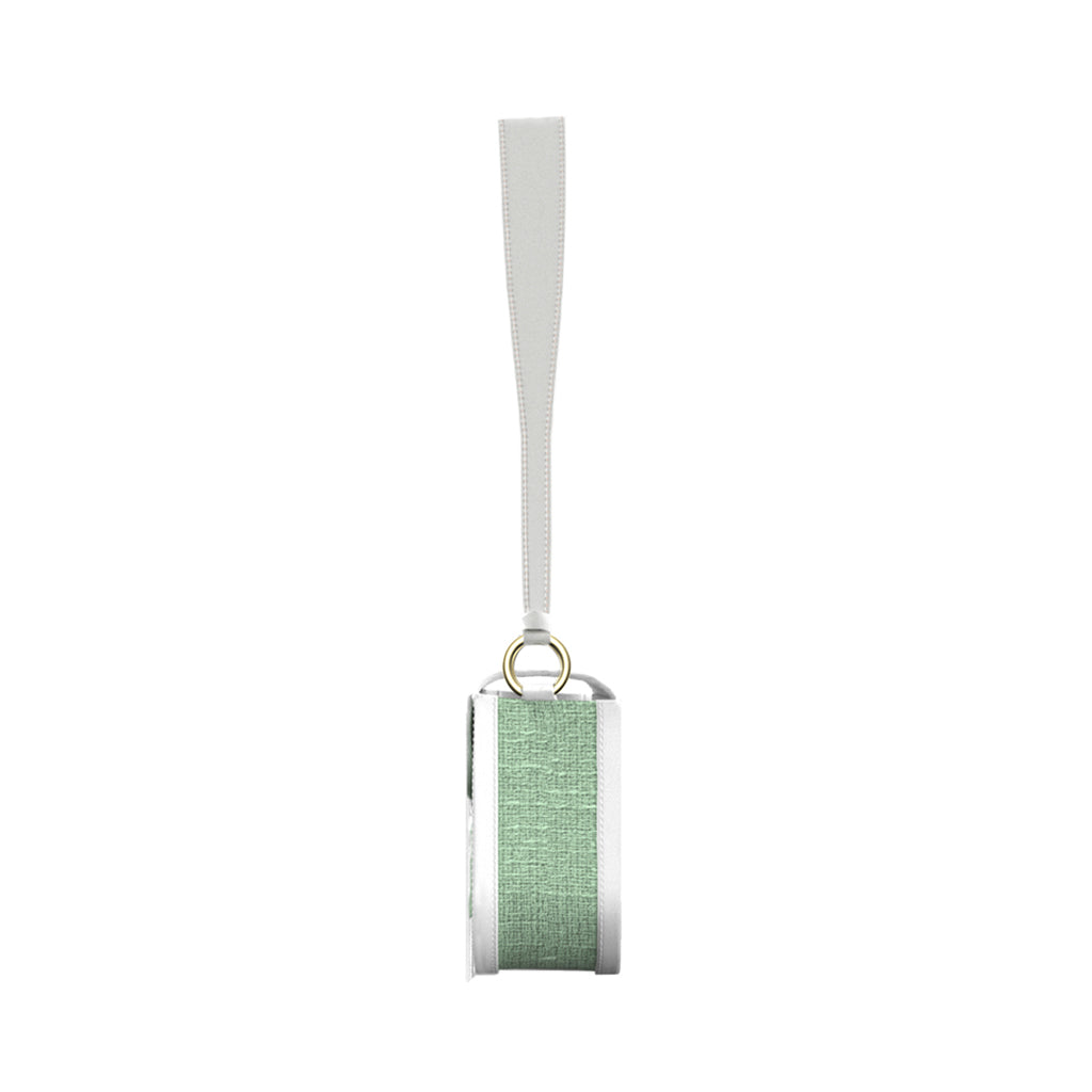 Green fabric-covered wireless speaker with a white strap