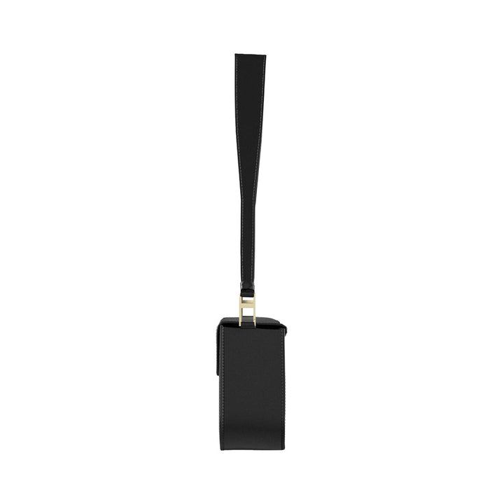 Side profile of a sleek black leather handbag with a long strap