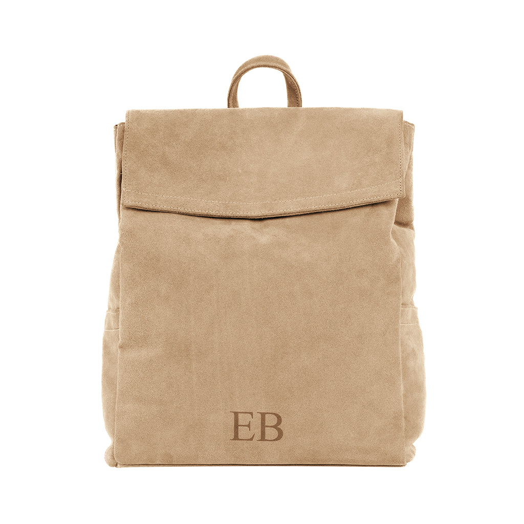 Tan suede backpack with top flap and EB monogram at the bottom front