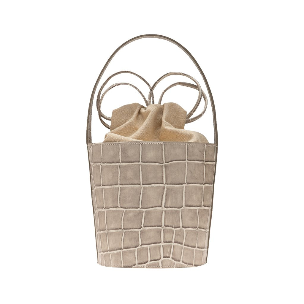 Beige crocodile-patterned handbag with leather handles and drawstring closure