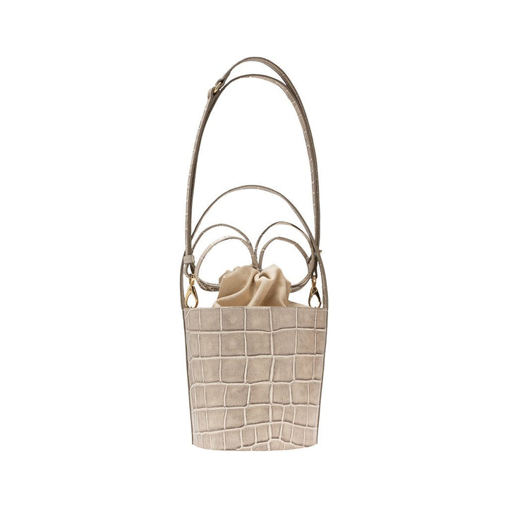 Beige crocodile-patterned leather bucket bag with drawstring closure and adjustable strap
