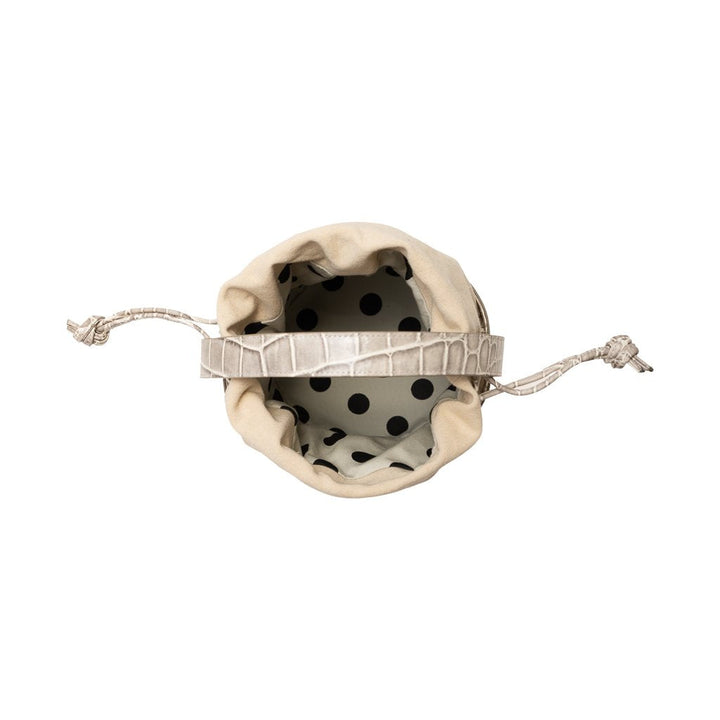 Top view of a beige drawstring bag with a polka dot interior