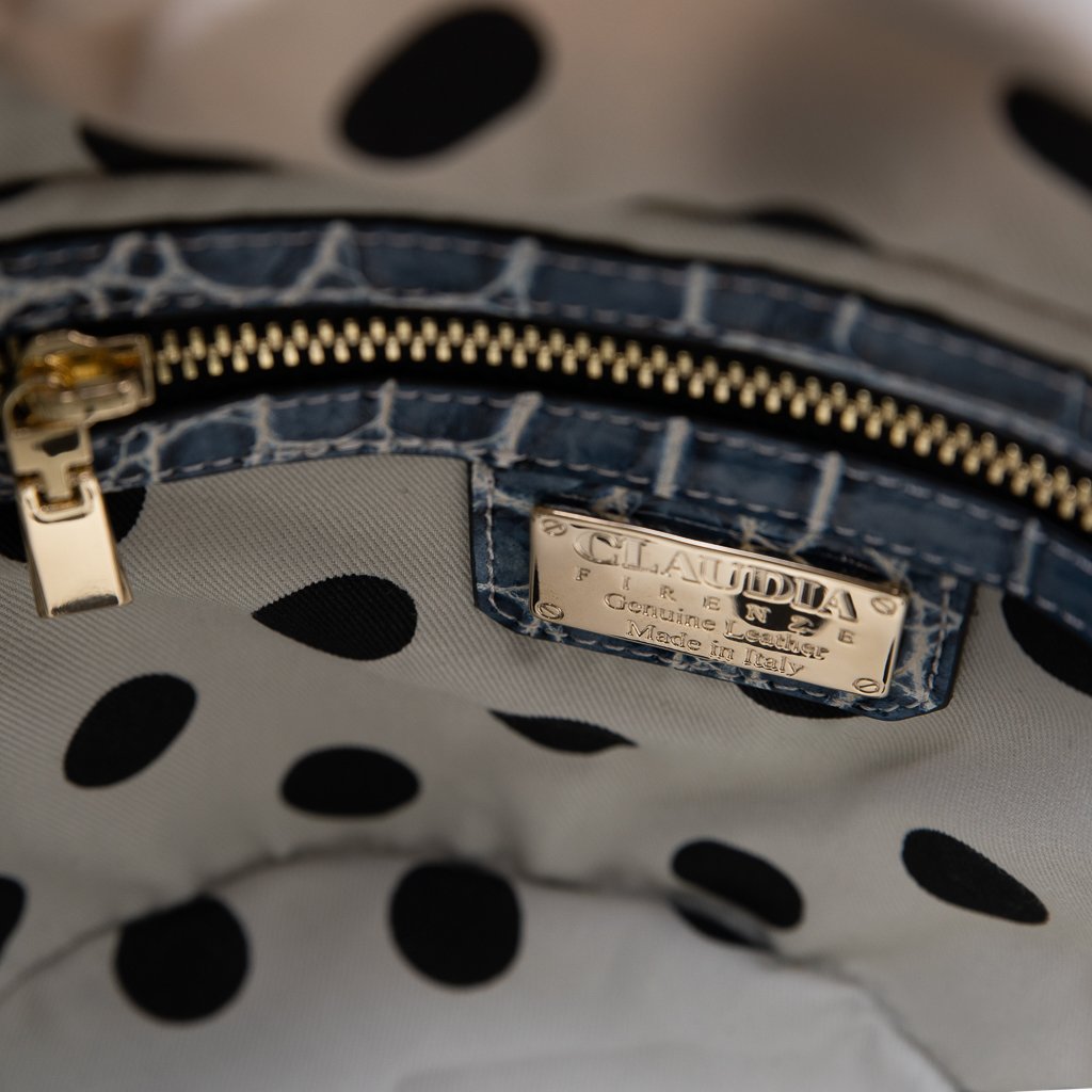 Close-up of a designer handbag interior with polka-dot lining and metal brand label
