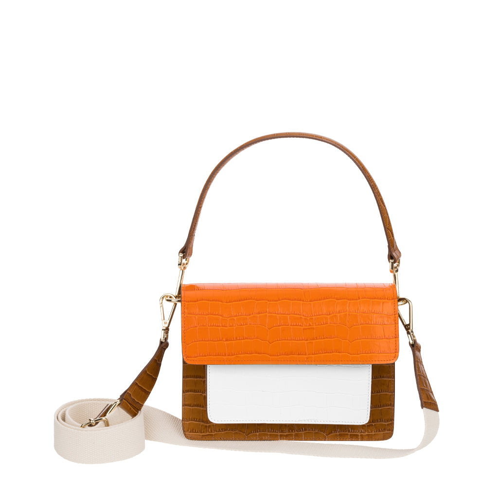Two-tone handbag with orange, white, and brown leather featuring a long adjustable strap
