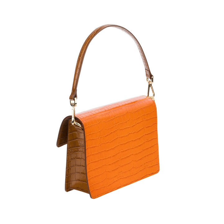 Orange crocodile leather handbag with brown handle isolated on white background