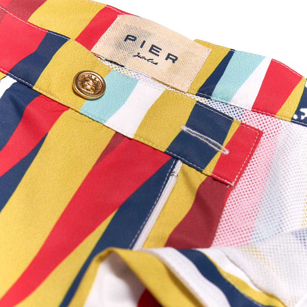 Close-up of colorful striped swim trunks with button and label