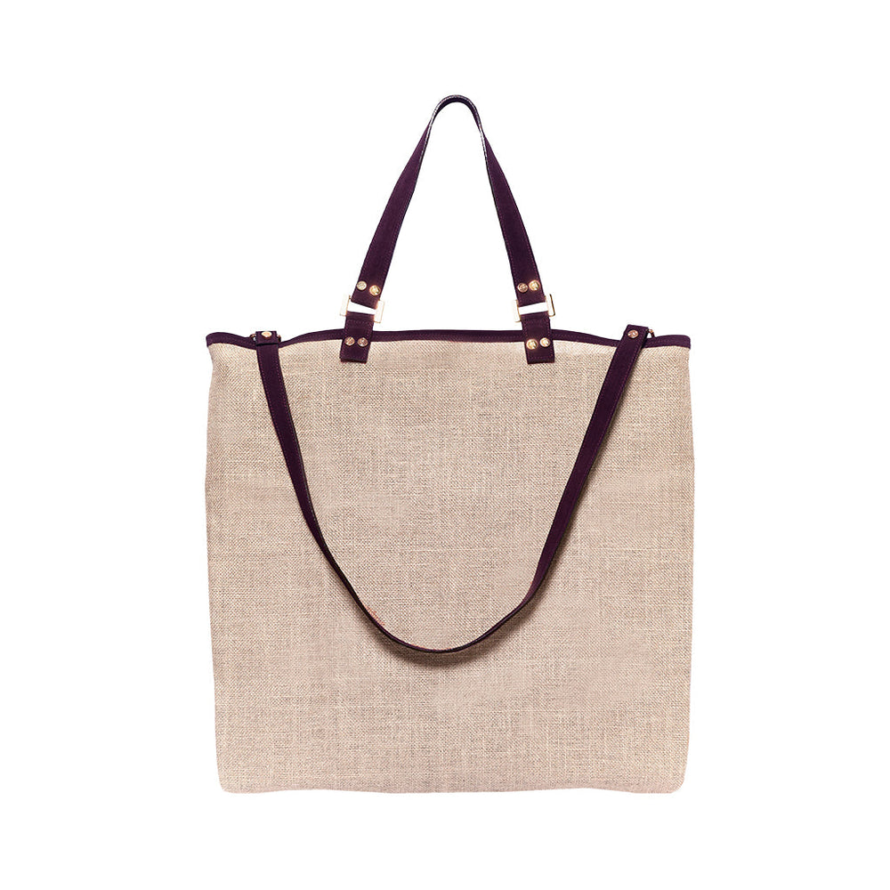 Beige canvas tote bag with dark brown leather handles and adjustable shoulder strap