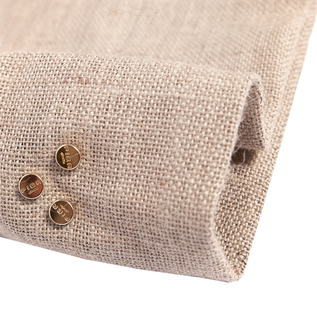 Close-up of a beige textured burlap fabric with three round, bronze buttons