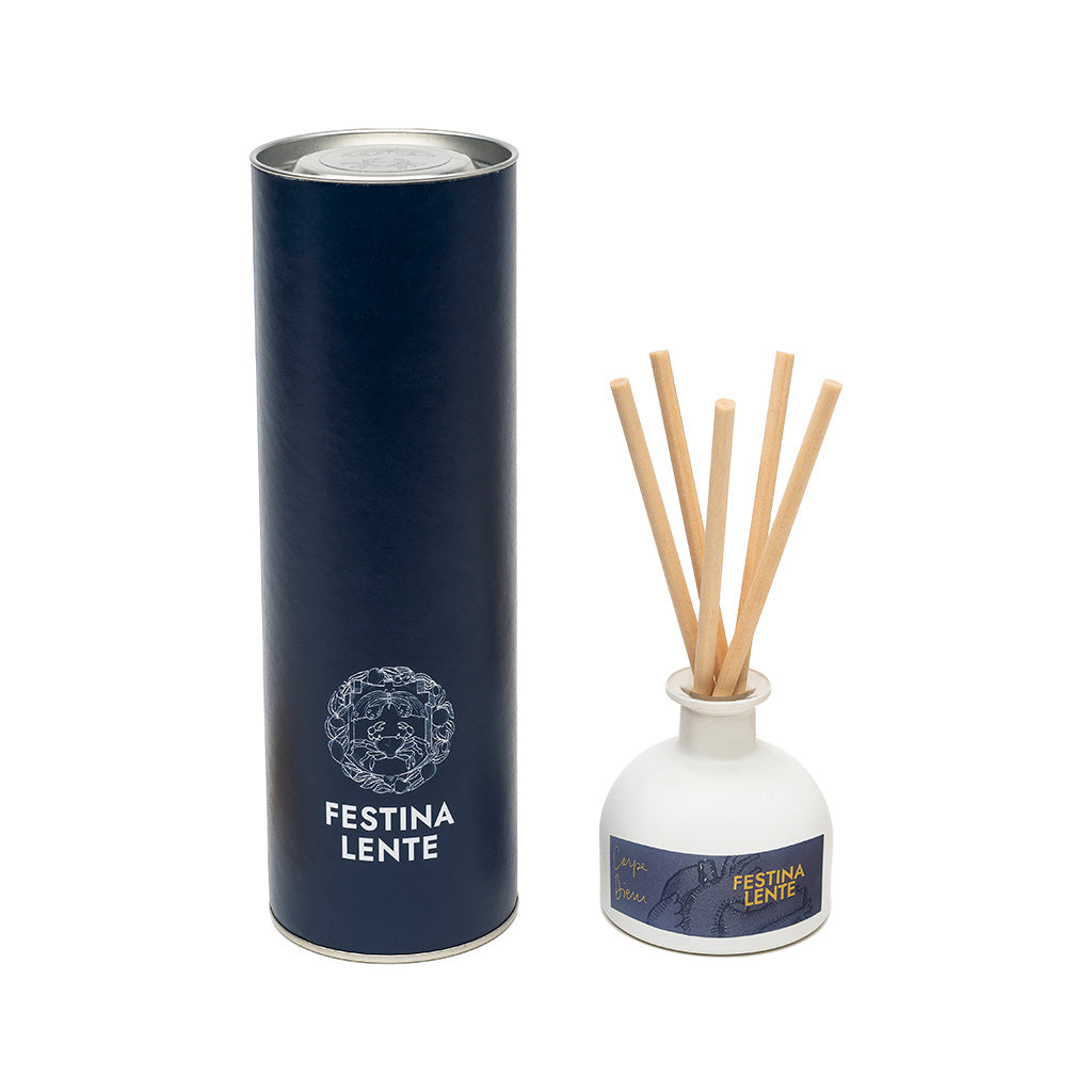 Festina Lente reed diffuser set with navy cylindrical packaging and white aromatic diffuser bottle