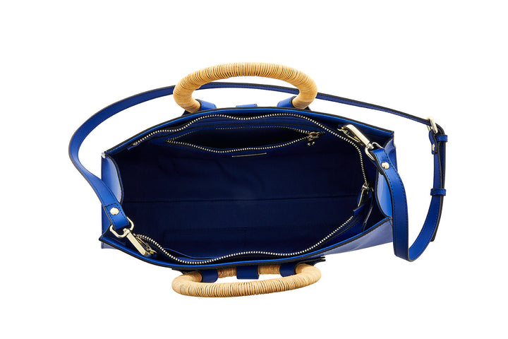 Open blue handbag with bamboo handles and interior zippers