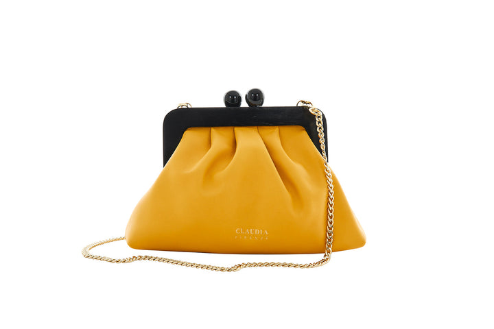 Yellow leather purse with a black frame and gold chain strap