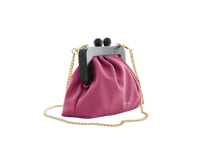 Magenta designer handbag with gold chain strap and black frame clasp on white background