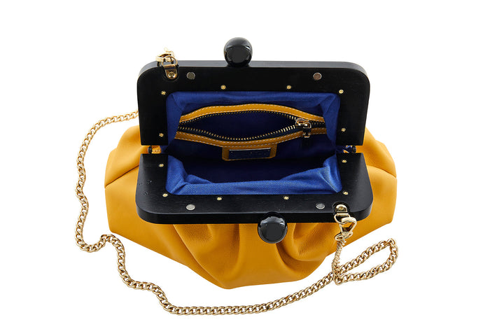 Yellow clutch purse with gold chain strap and black frame, featuring blue interior with a zippered pocket