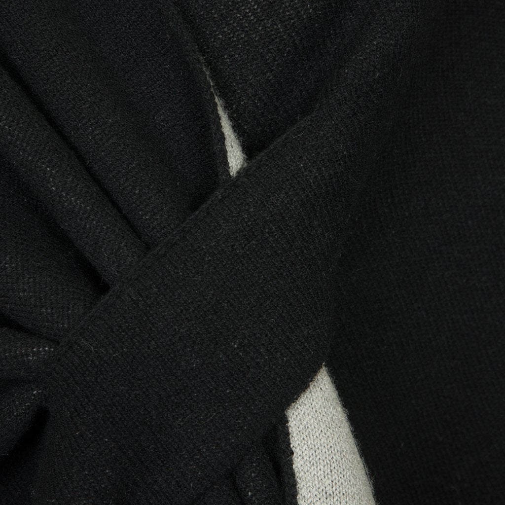 Close-up of a black knitted fabric with intertwined texture