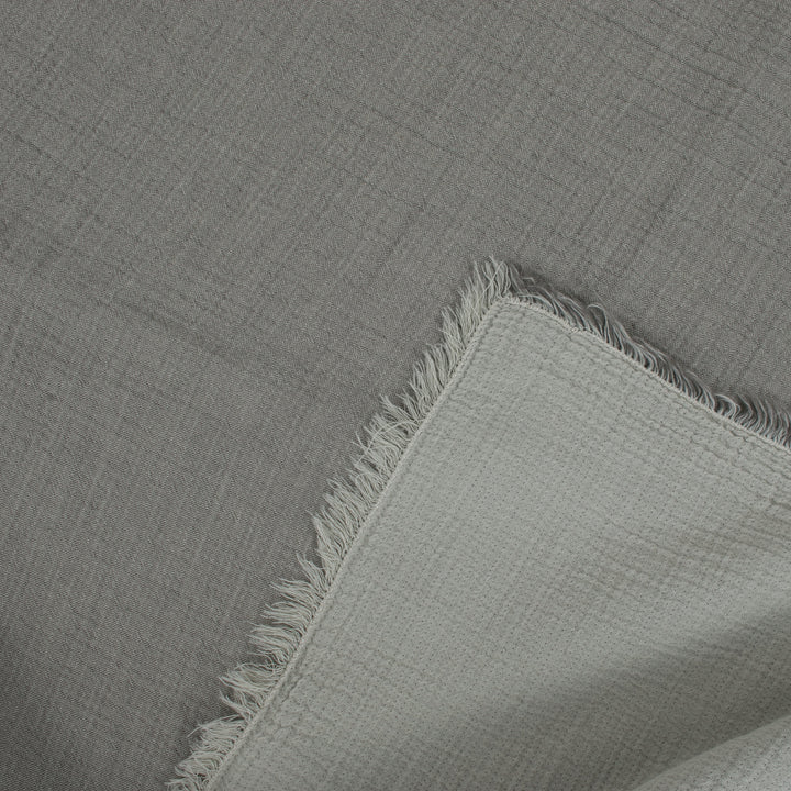 Close-up of a gray textured fabric with frayed edges