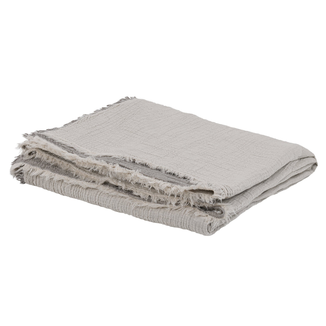 Beige folded blanket with frayed edges