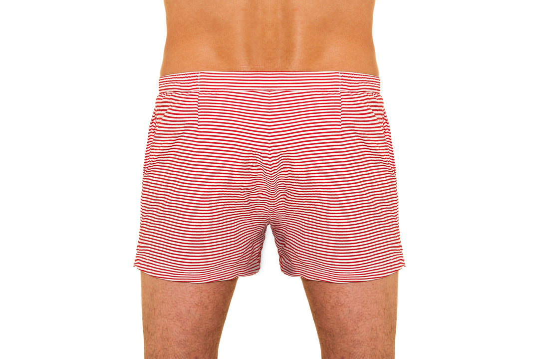 Back view of a person wearing red and white striped swim trunks