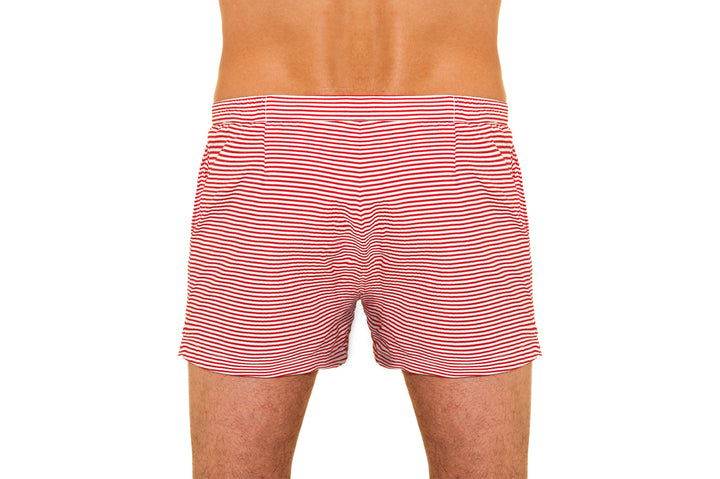 Back view of a person wearing red and white striped swim trunks