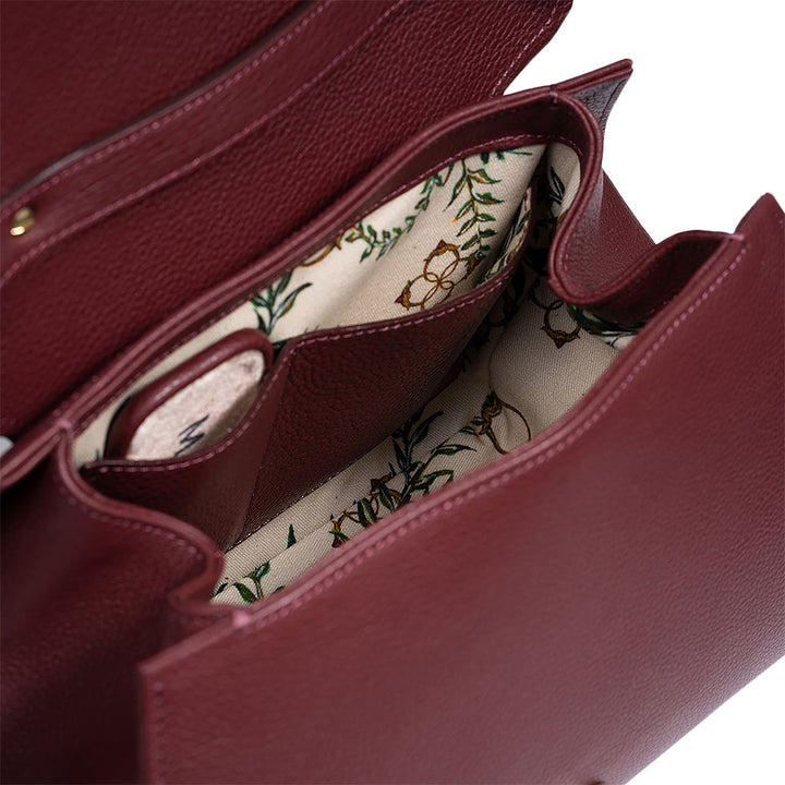 Open burgundy leather handbag showing floral interior lining and multiple compartments