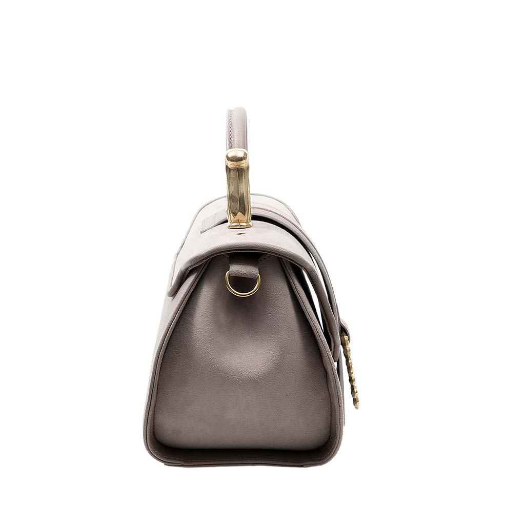 Side view of a stylish gray leather handbag with gold hardware