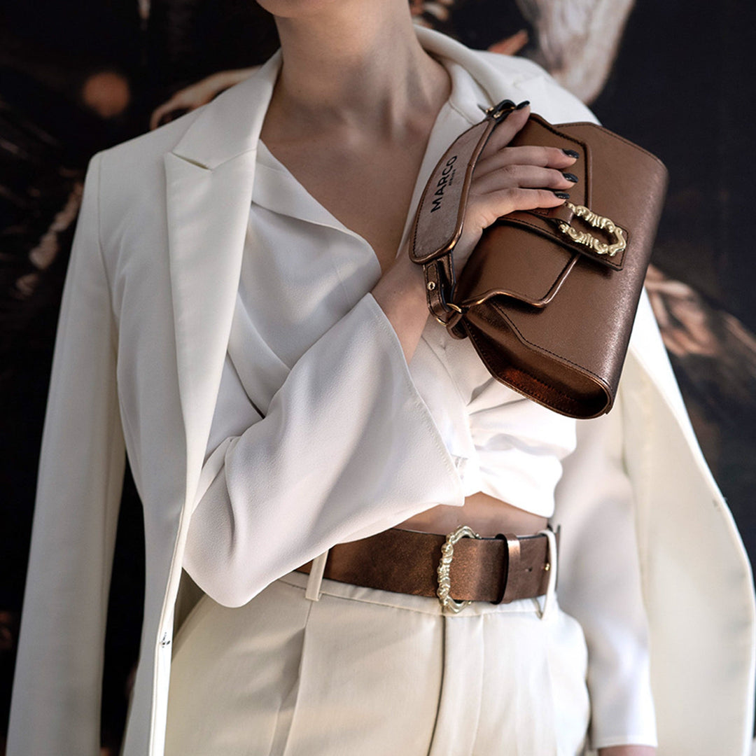 Woman in stylish white suit holding a designer brown leather handbag
