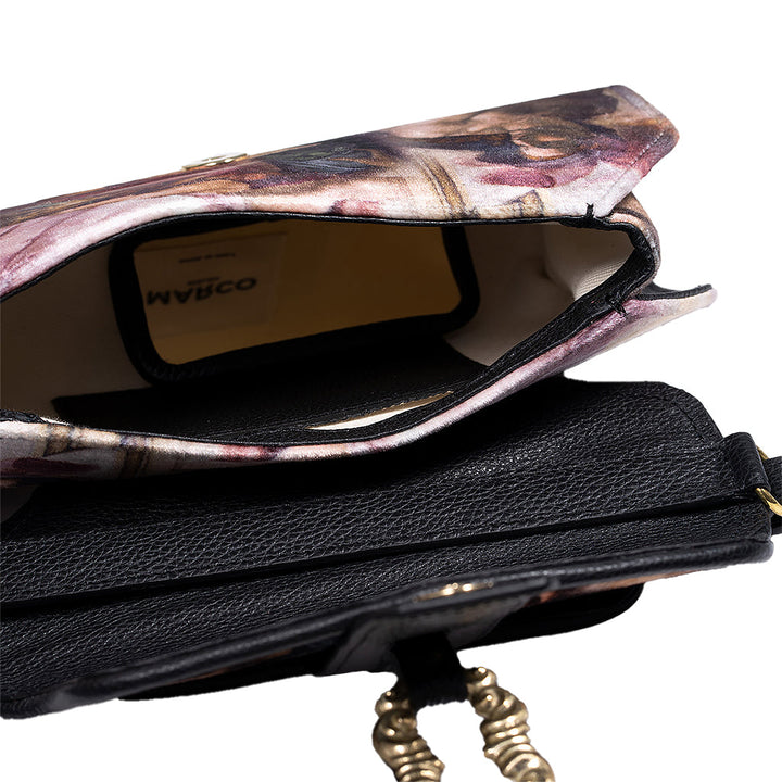 Close-up of an open black and floral crossbody handbag with a visible beige interior