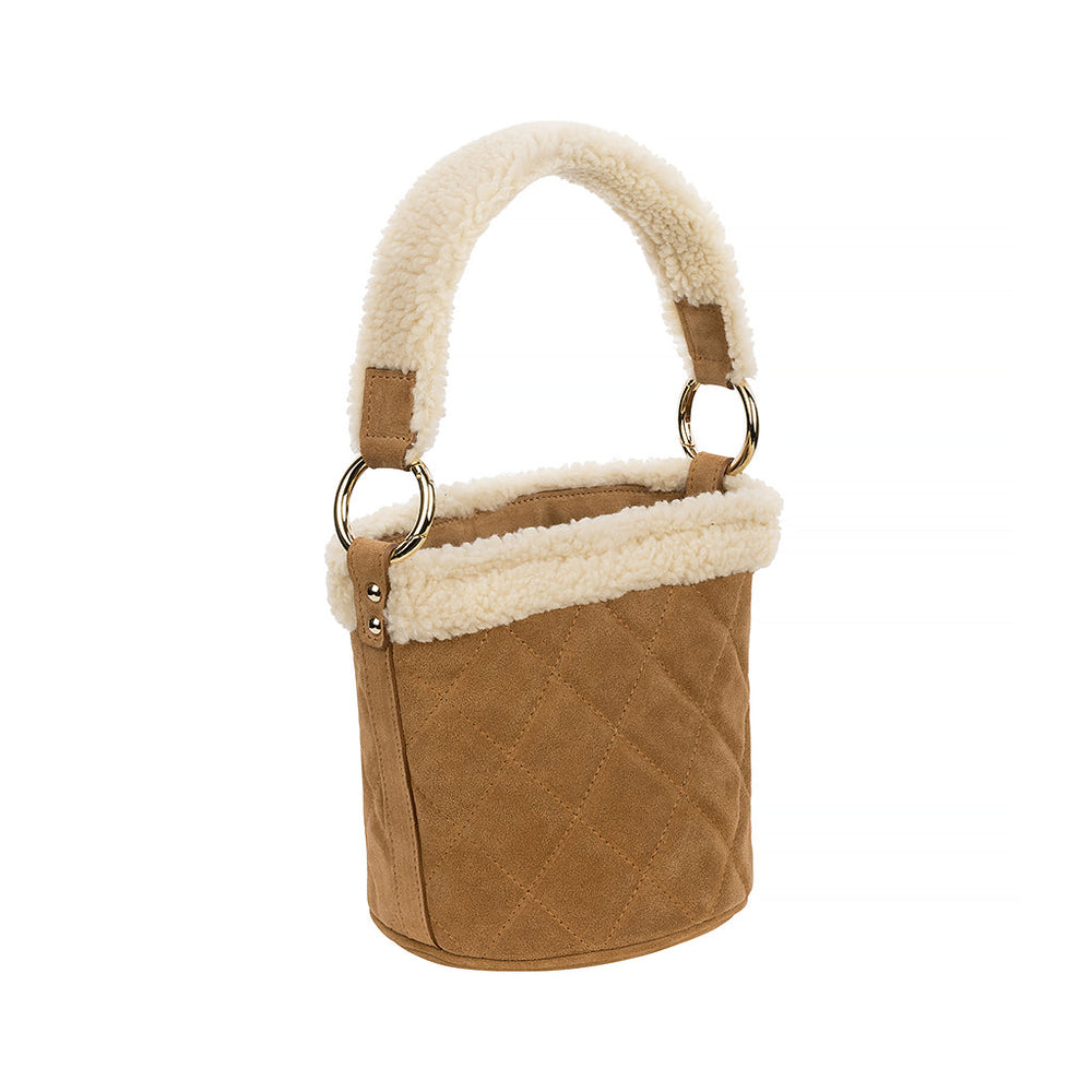 Tan suede bucket bag with quilted design and plush shearling trim handle