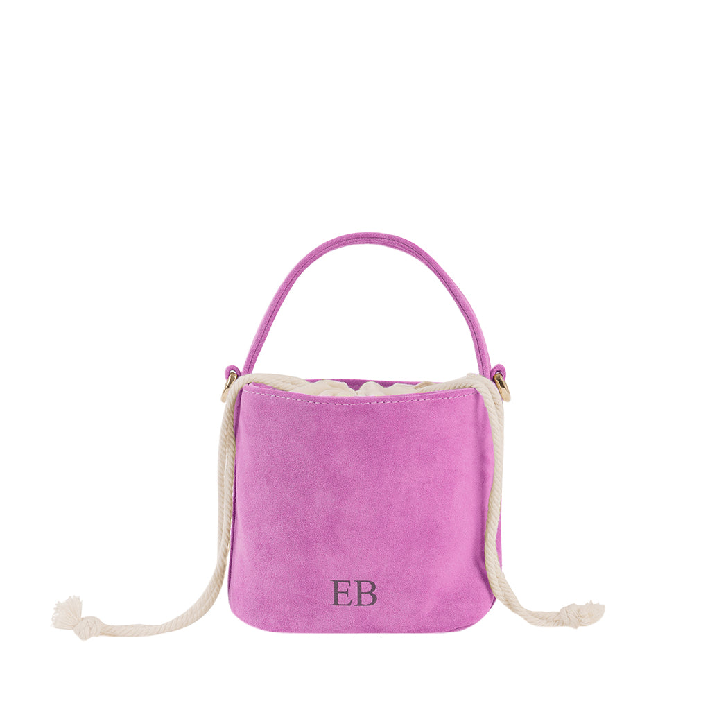 Pink suede bucket bag with white rope handles and initials EB on the front