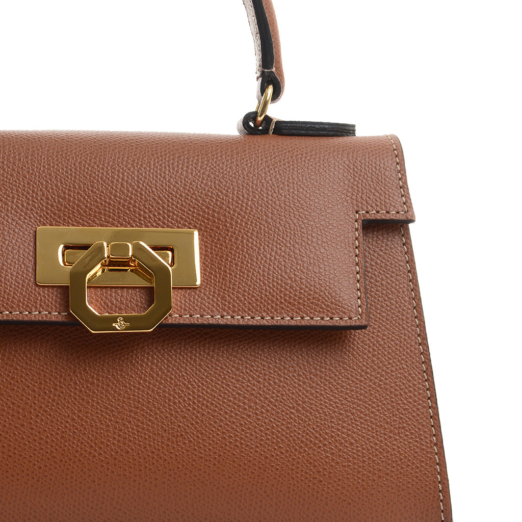 Close-up of a stylish brown leather handbag with gold clasp detail