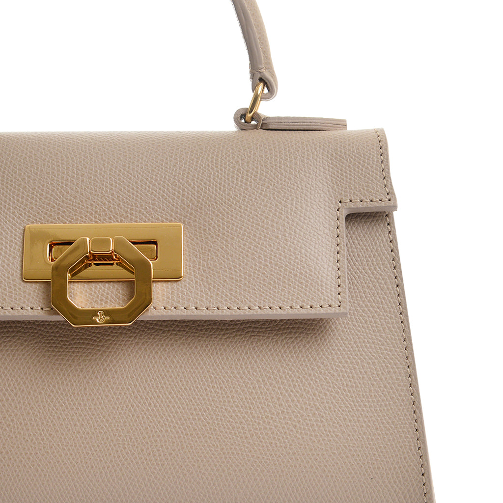 Beige leather handbag with gold hardware and textured design