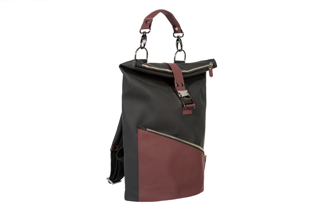 Black and burgundy leather backpack with roll-top closure and external zippered pocket