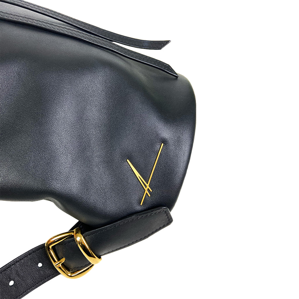 Black leather handbag with gold buckle and designer logo