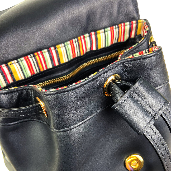Close-up of an open black leather handbag with a striped interior and gold hardware