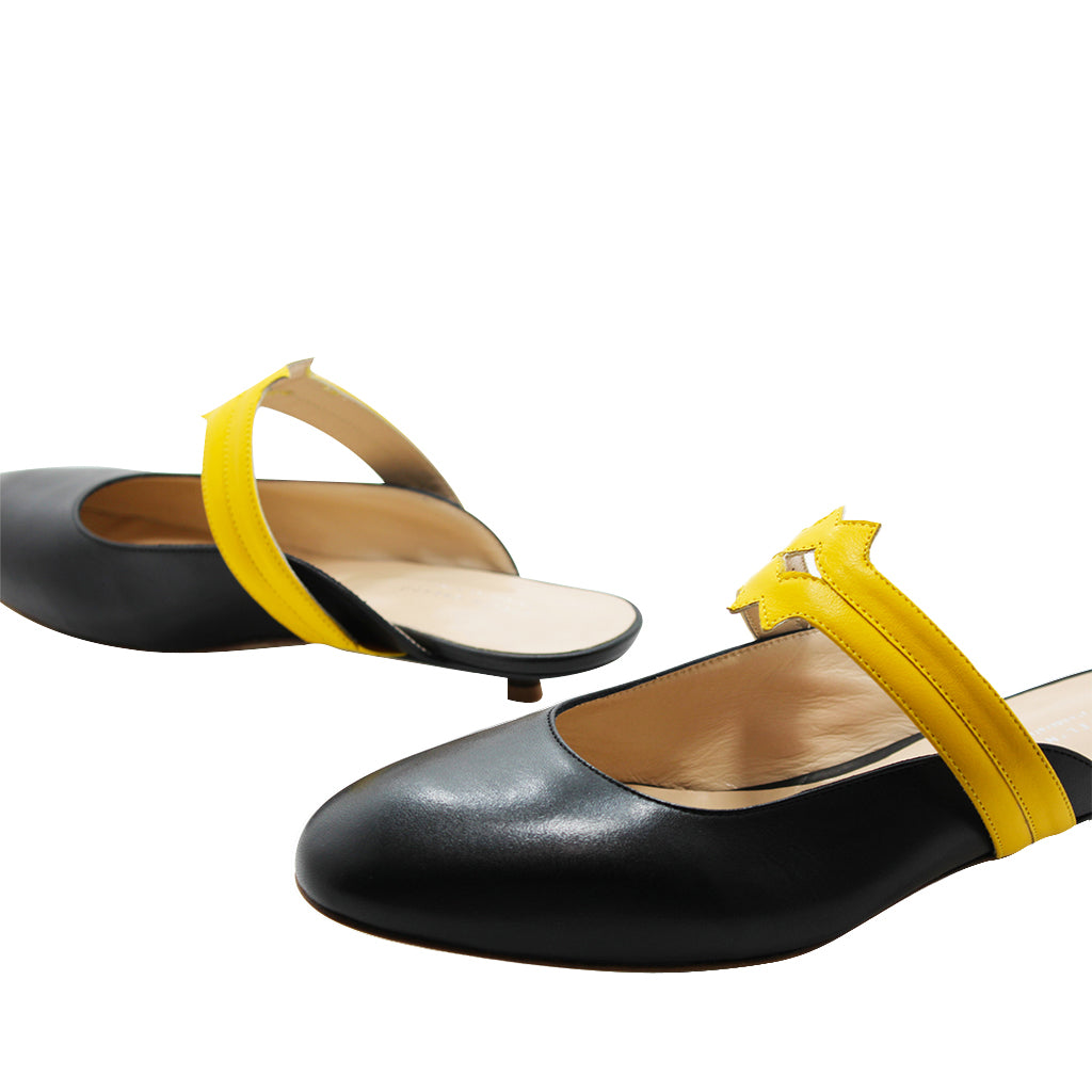 Black and yellow women's flat shoes with a back strap on a white background