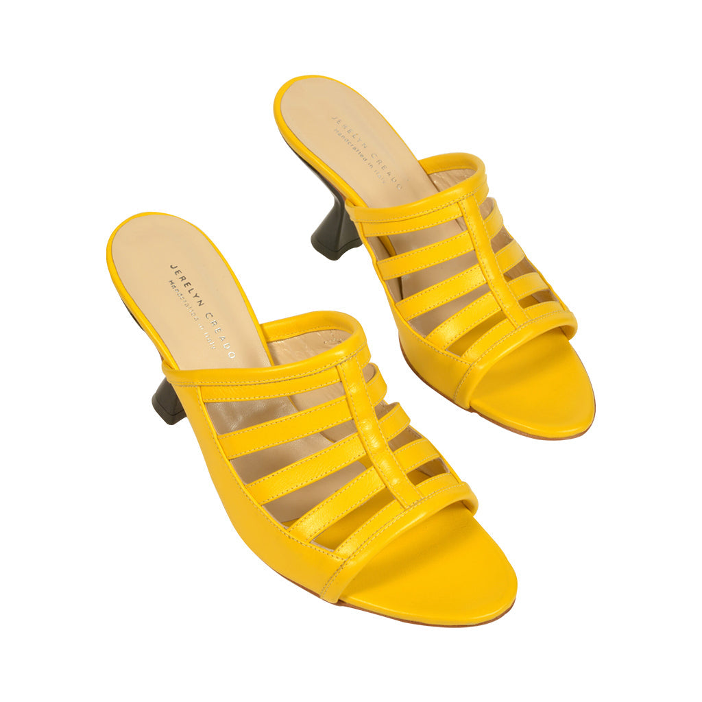 Yellow strappy heeled sandals on white background