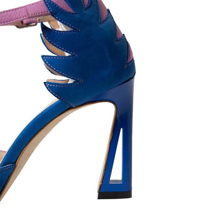 Close-up of a vibrant blue high-heeled shoe with unique cutout and purple accents