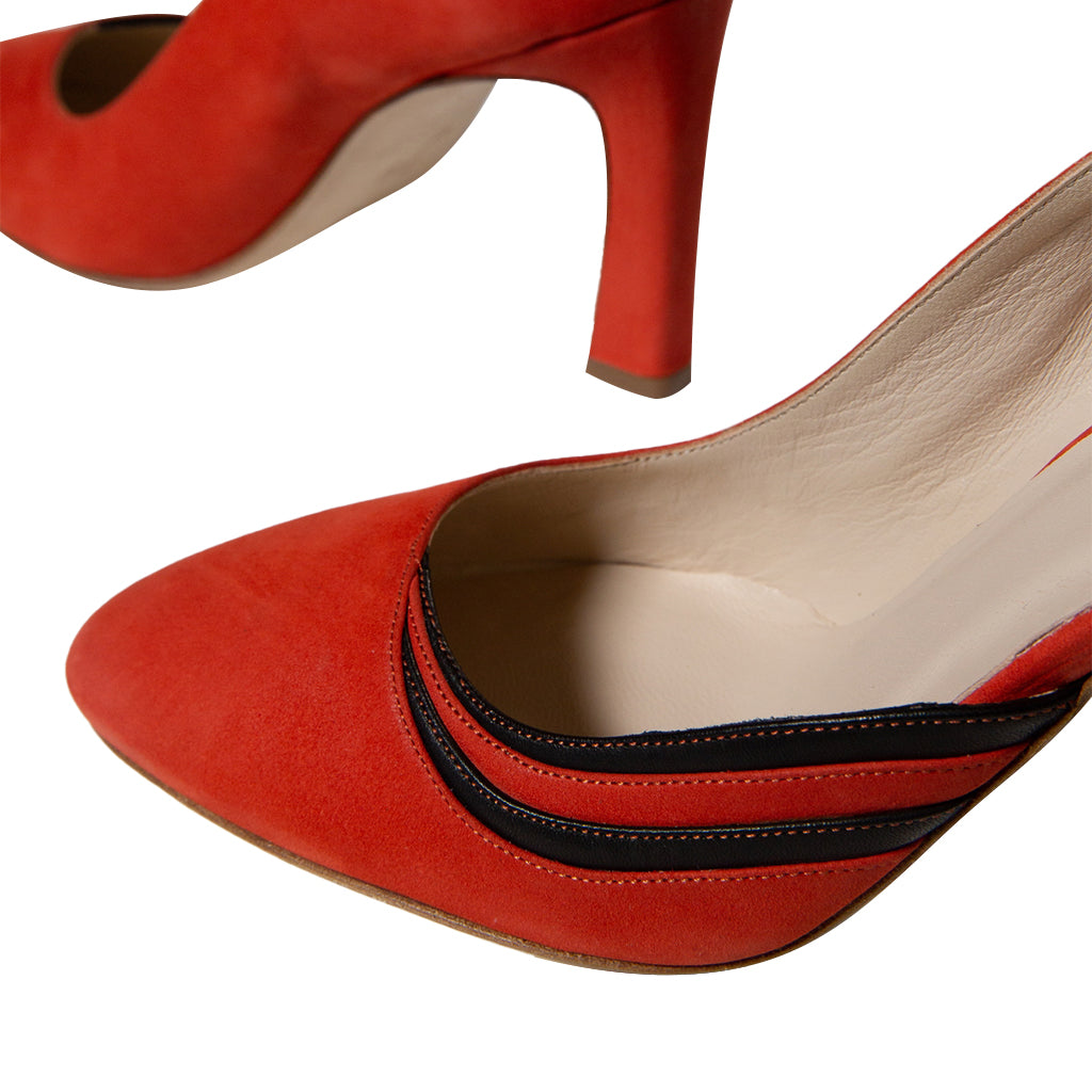 Close-up image of elegant red high-heeled shoes with black accents