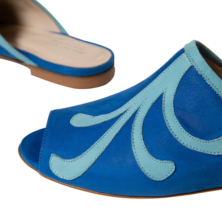 Close-up of blue and turquoise women's open-toe sandals on a white background