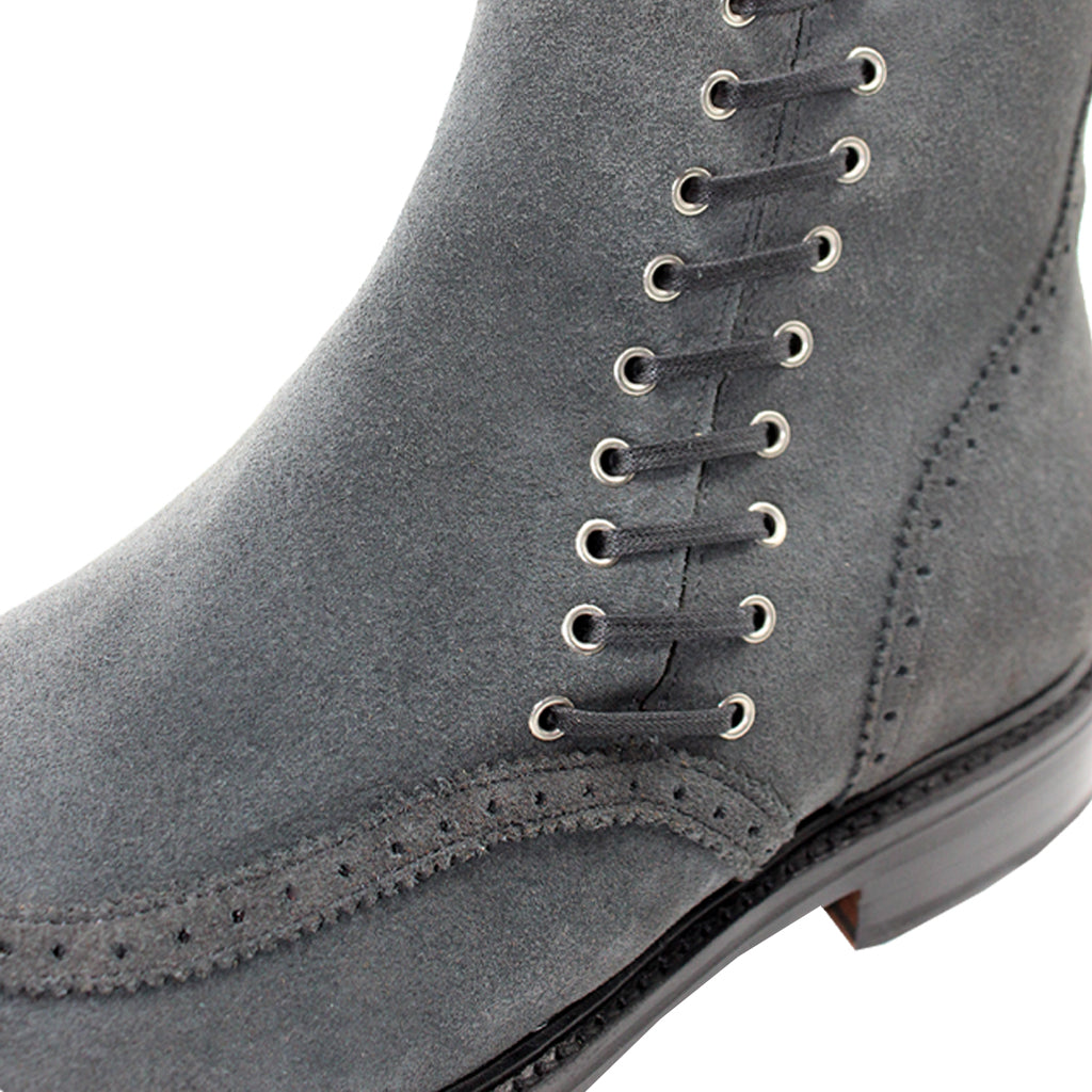 Close-up of gray suede lace-up boot with detailed stitching