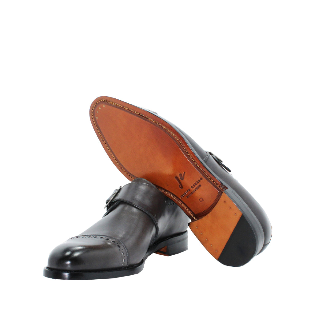 Elegant dark brown leather dress shoes with a single buckle and polished wooden sole