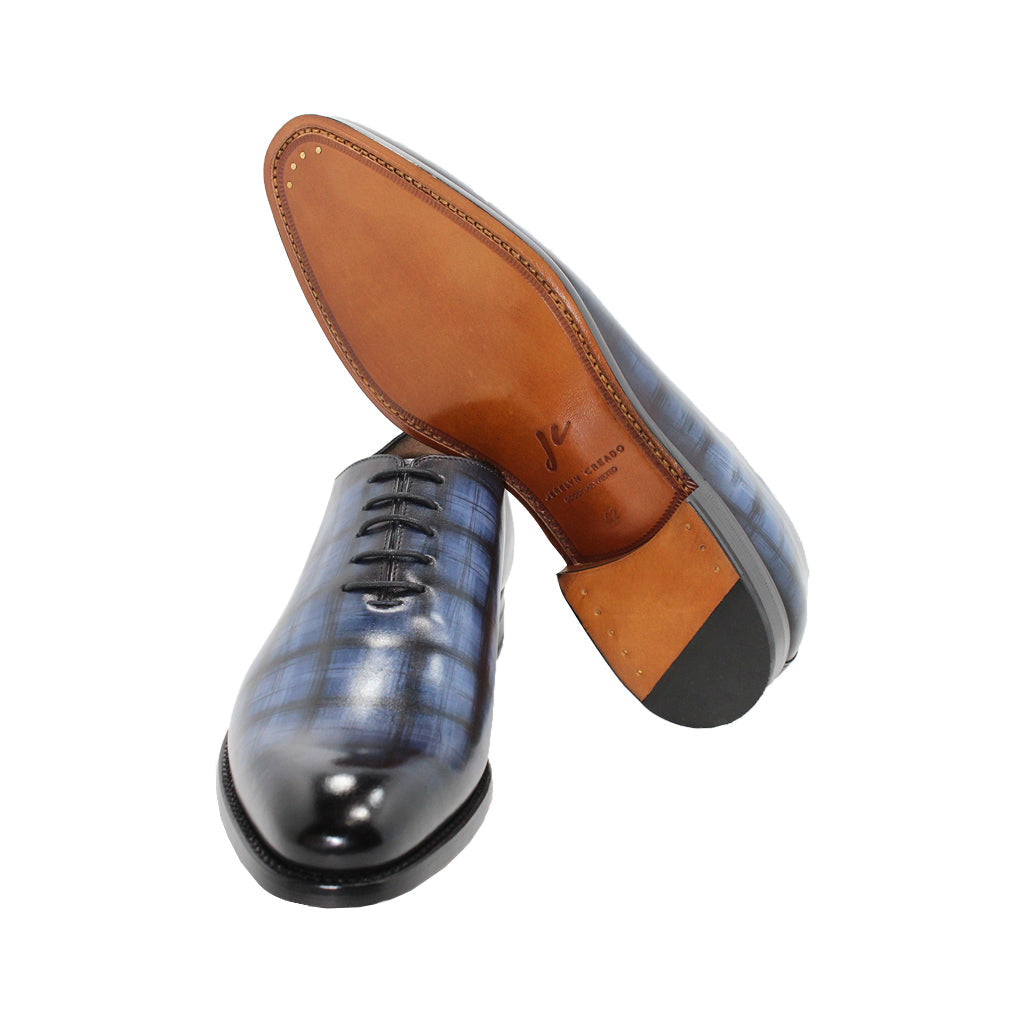 Handmade leather dress shoes with blue plaid pattern and tan leather soles